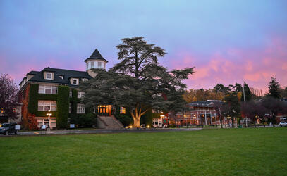 An early morning photo of the School House Building with a dark but colourful sky in the background. 