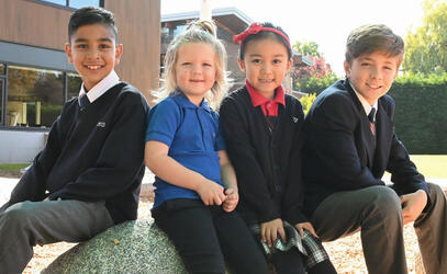 Four Junior School students gather outside
