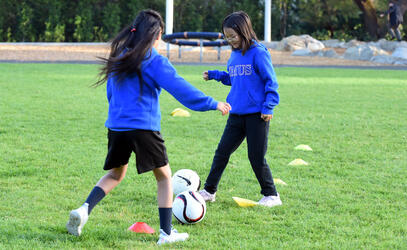 Two Junior School students practice soccer
