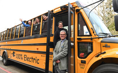 Staff and students pose with the new electric bus ahead of it's first official day on the road.