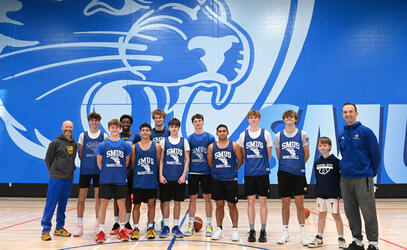 Team players pause during practice for a team shot in front of the Blue Jag mural