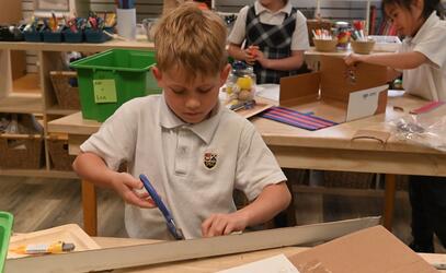 Grade 2 student uses scissors and cardboard in the iLab