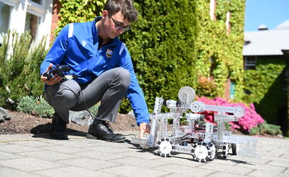 Grade 9 students work with engineering robots in a golfing challenge