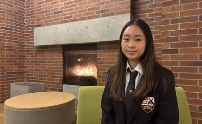 Kayler Kim portrait by the fireplace in the Sun Centre Commons