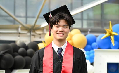 Valedictorian Jaden Berger-North poses in his regalia on graduation day.