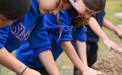 Middle school students building a mud wall