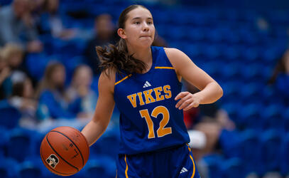 Avery Geddes dribbles the basketball up the court in her UVic Vikes uniform