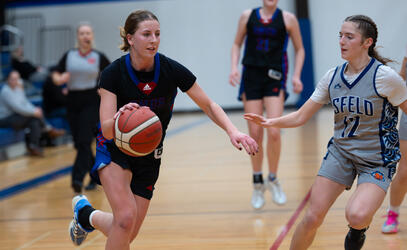 Mya Beare dribbles in basketball past a Mark Isfeld player.