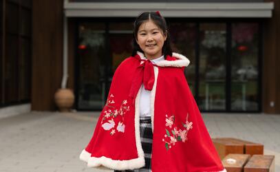 Emiyl Wang smiles at the camera in traditional dress for Lunar New Year