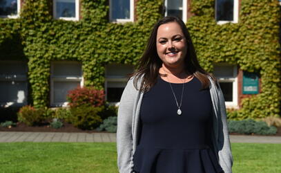 A portrait of Cara Lee in front of School House