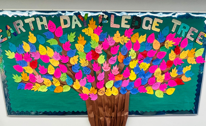 Middle School students create a tree with leaves sharing pledges to the planet