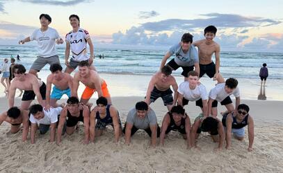SMUS Australia tour Senior Boys Rugby team form a pyramid on the beach