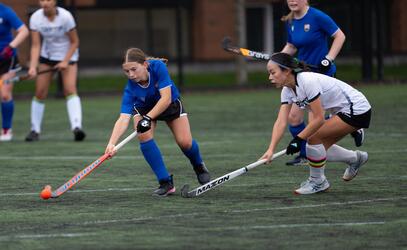 Senior Girls field hockey player Piper Geddes is pressured by a player from Crofton House. 