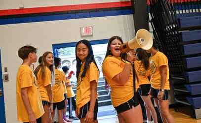 Two WEB Leaders pose in a sea of yellow shirts