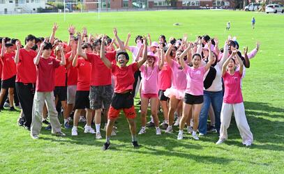 School spirit at its finest as Barnacle and Winslow cheer with their hands up in their house colour shirts. 