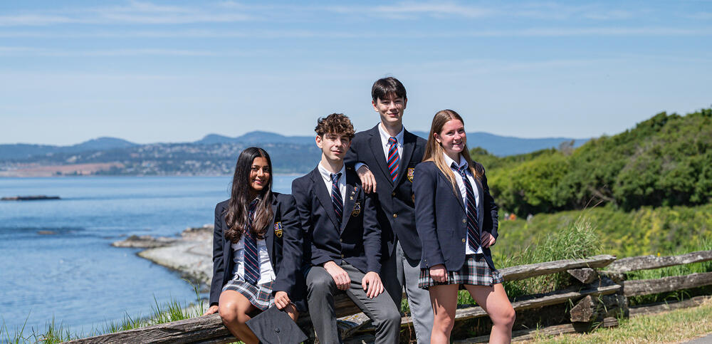 Four Grade 12 students pose along the Dallas Road coast