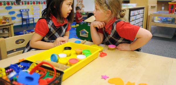 Two Kindergarten students in conversation over Playdoh