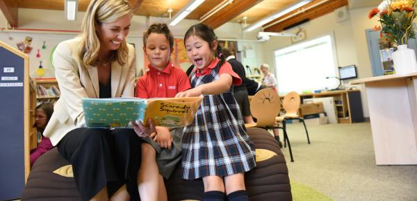 Kindergarten teacher reading storybook with students