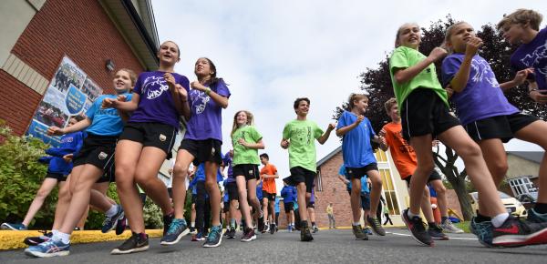 Many Middle School students in house t-shirts doing a run