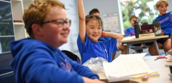 Middle School student raising hand in class