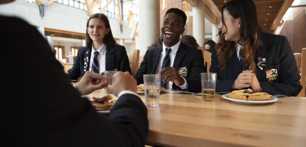 Senior School friends sharing a meal in the dining hall