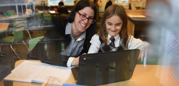Junior School teacher and student working with a laptop