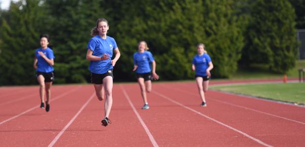Middle School students run during a track and field racing event
