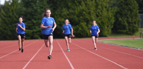 Middle School students run during a track and field racing event