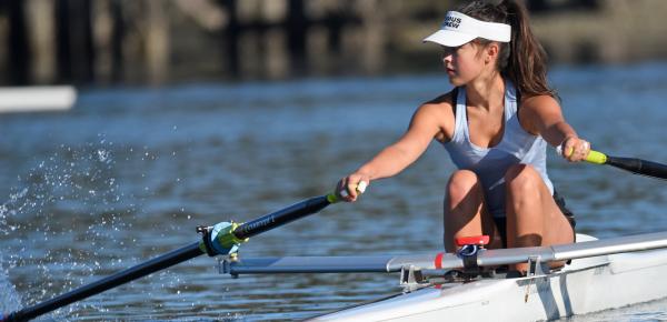 A rower sits in a single shell boat during practice