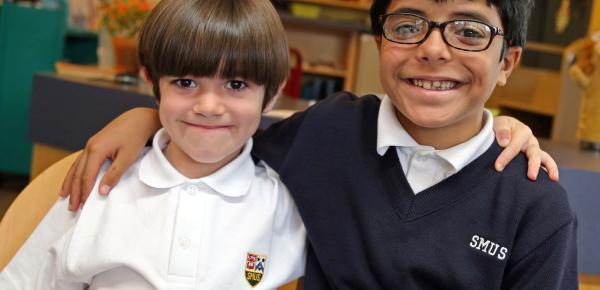 Two Junior School students smile for a photo in the library