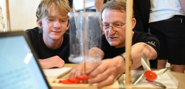 Senior School student closely watching a teacher's demonstration