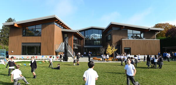 Students play on the field behind the Annex