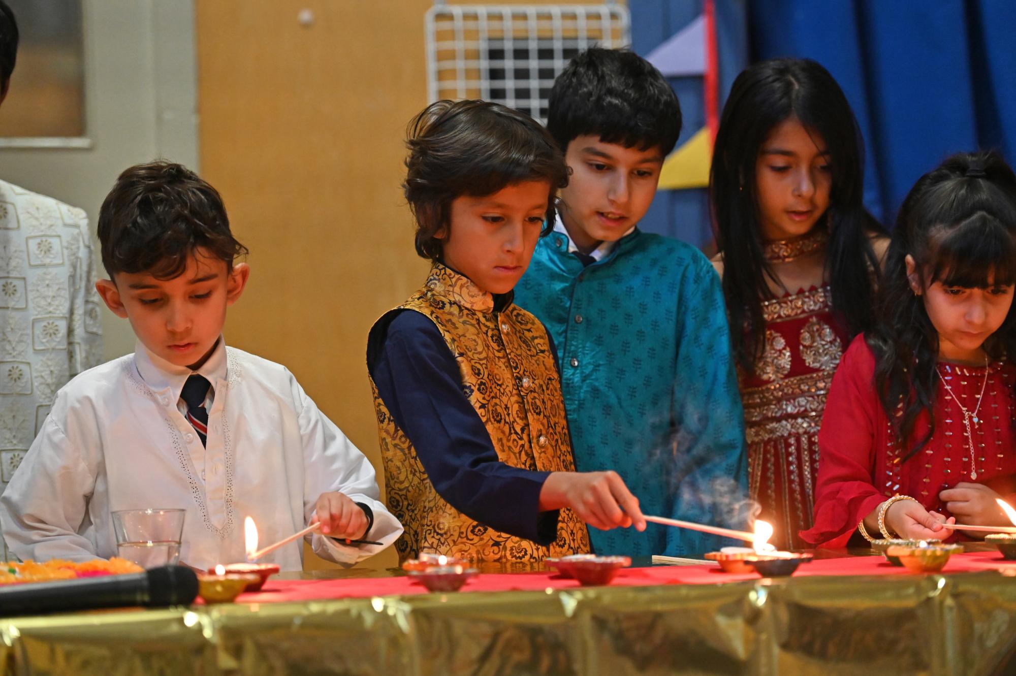 Junior School students light diyas during a Diwali celebration