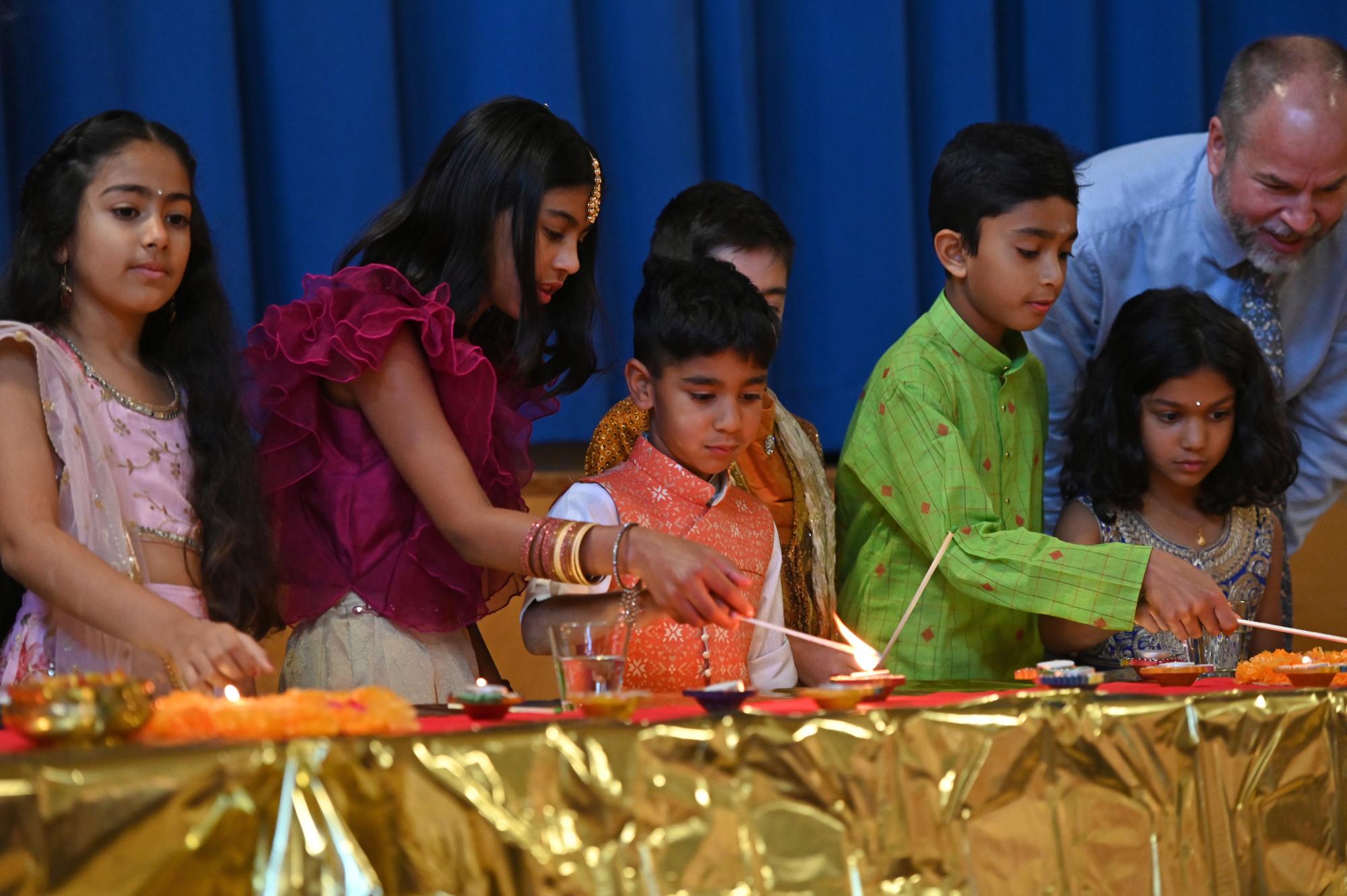 Junior School students light diyas during a Diwali celebration