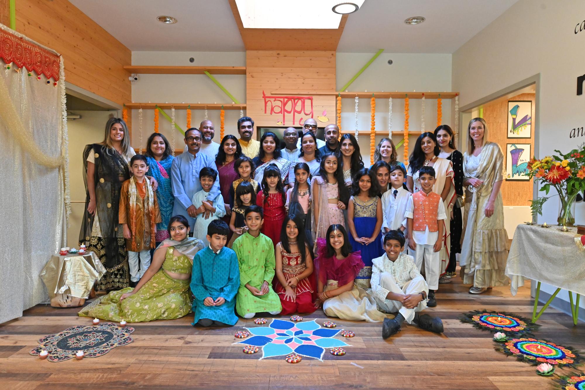 Junior School families stand in the beautifully decorated foyer after a Diwali celebration