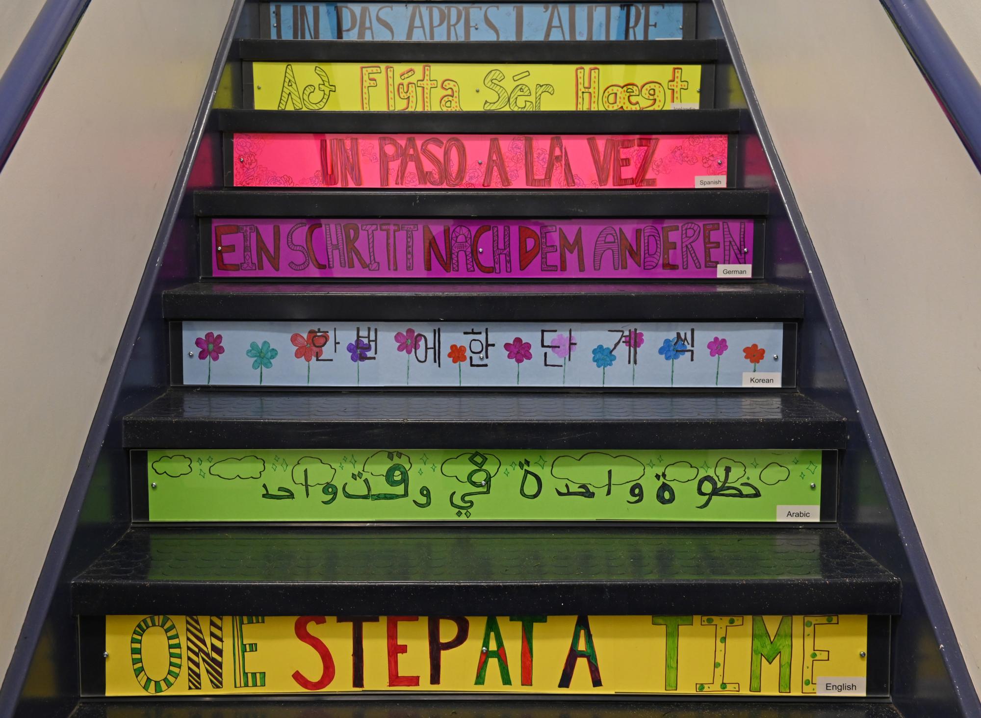 Colourful messages in multiple languages adorn the front of a set of stairs at the Middle School