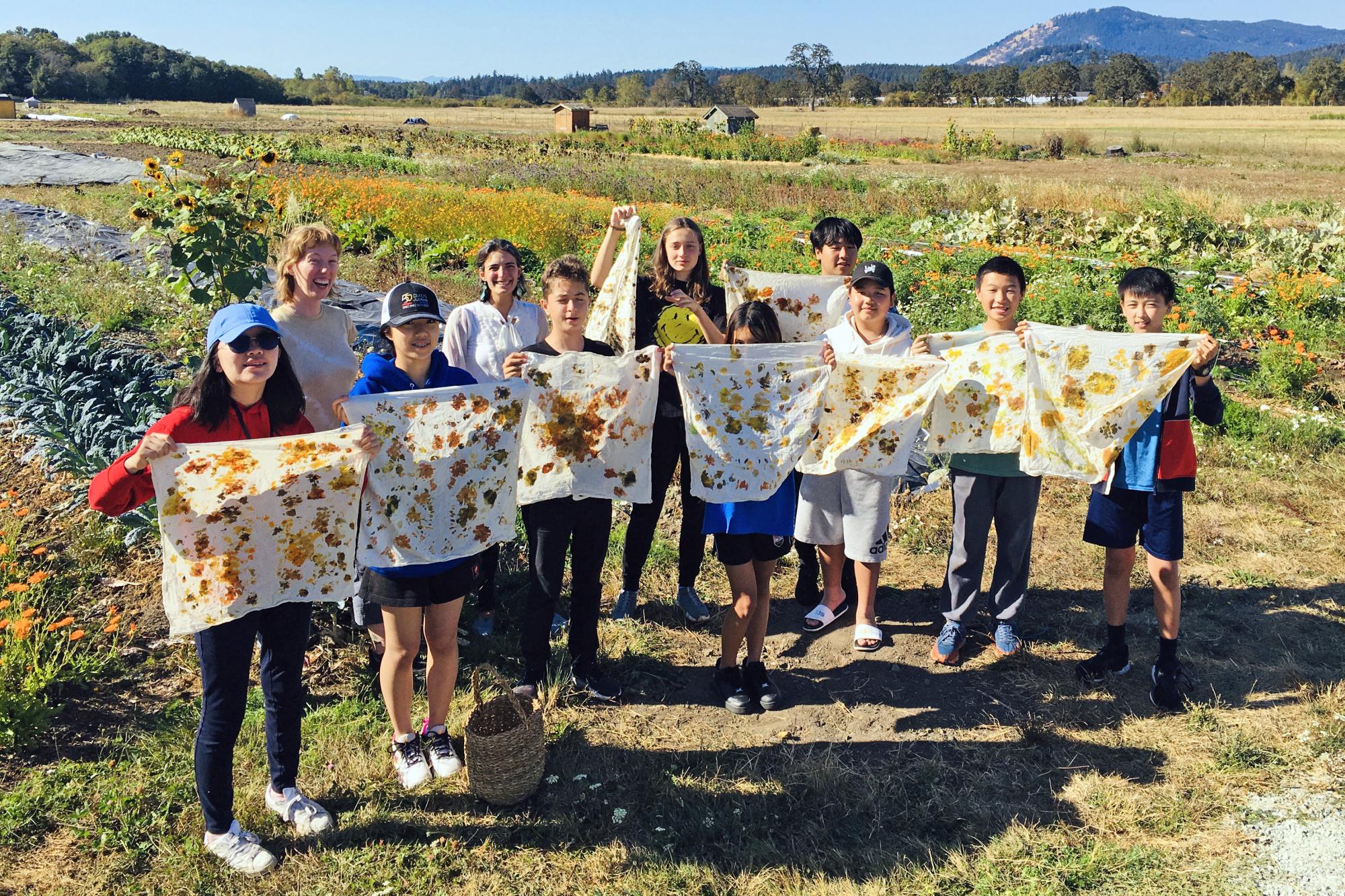 Grade 8 boarding students pose with their dyed fabrics during a group activity