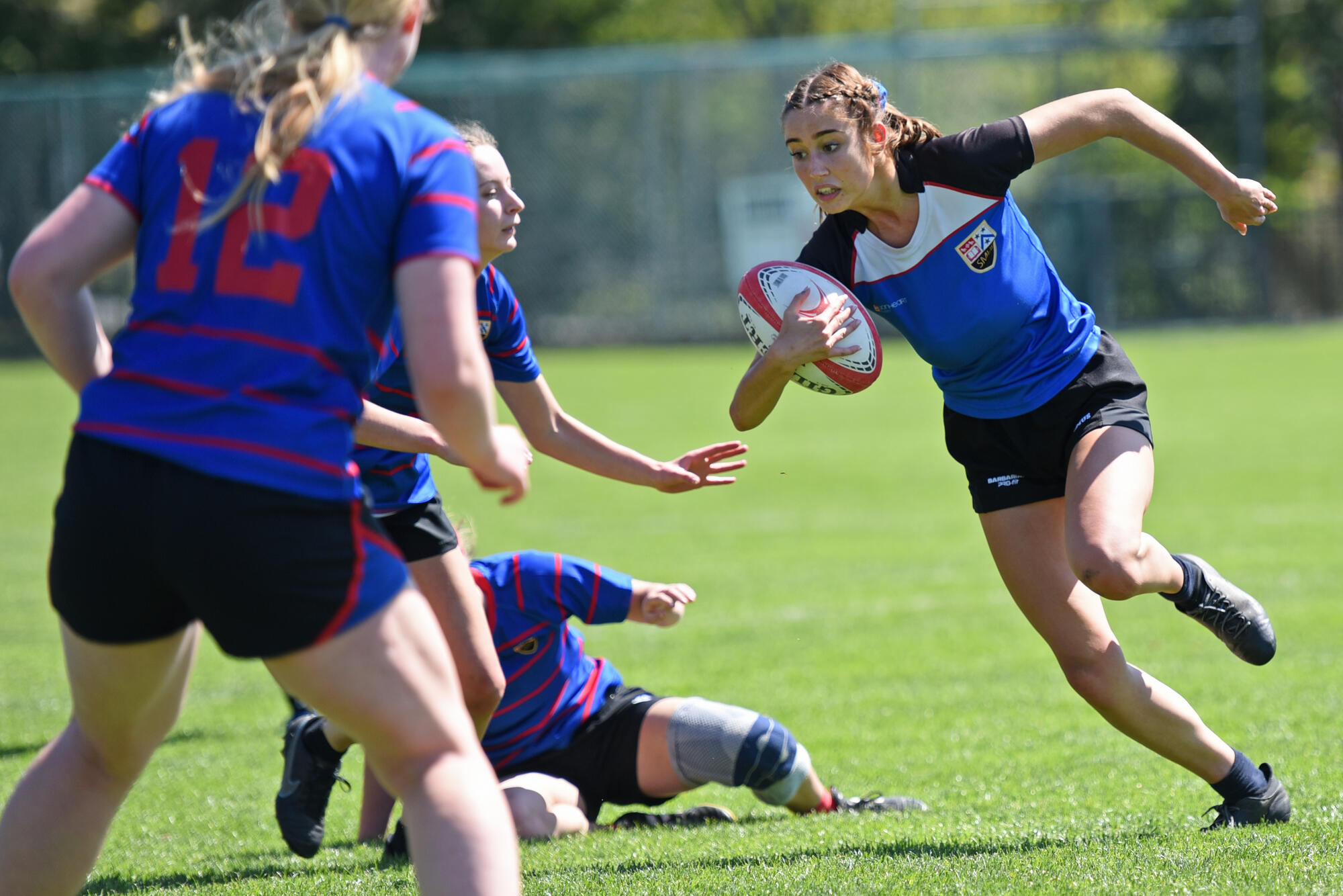 A member of the Girls Rugby team runs with the ball