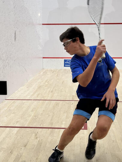 a member of the Blue Jags Squash team backhands the ball at the B.C. Junior Open tournament over the weekend.