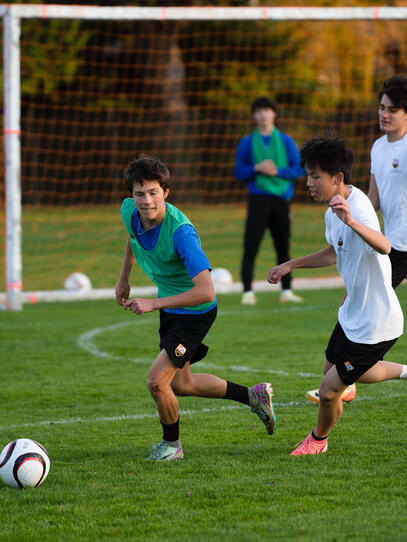 3 boys practice their skills on the field