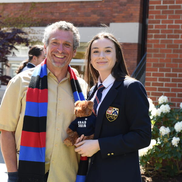 Alumni and SMUS graduate with a grad bear