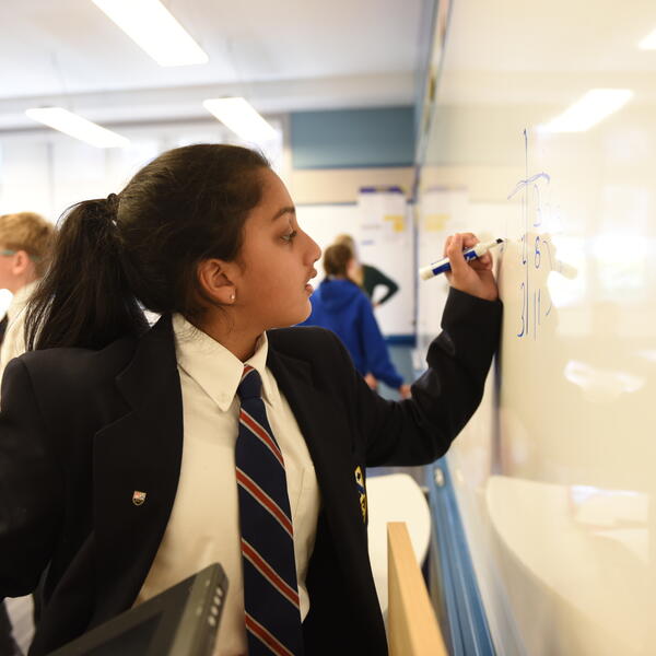 Middle School student doing math on the classroom whiteboard