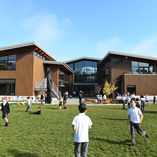 Students play on the field behind the Annex