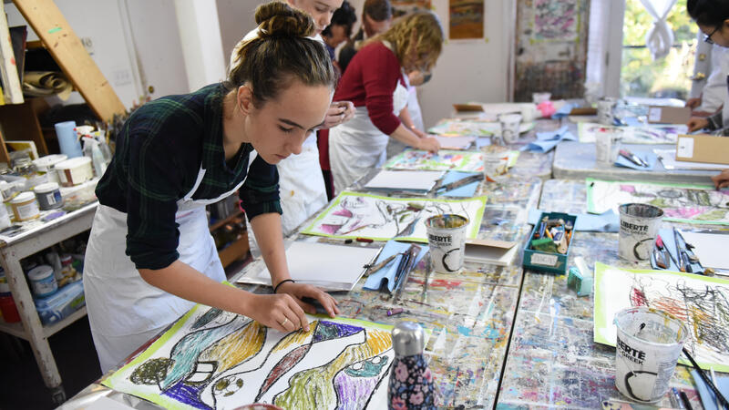 Experiential students in an art studio working with pastels