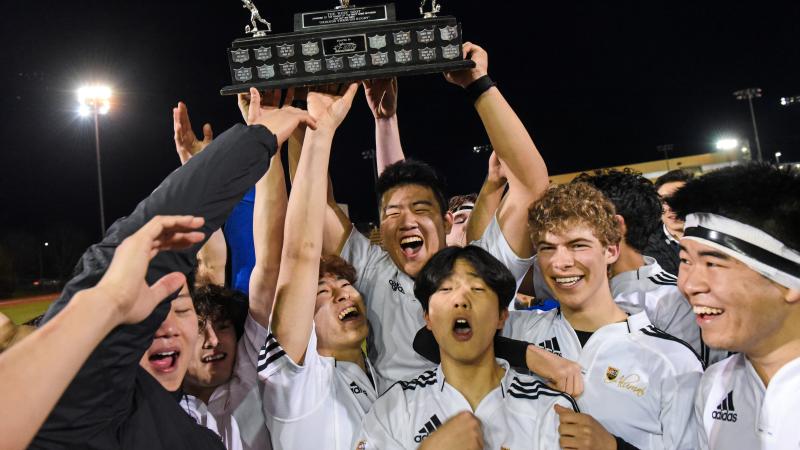 Senior Boys Rugby players lift the Boot Game trophy in celebration