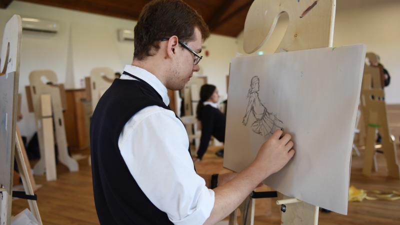 Senior School student drawing on an easel in Brown Hall