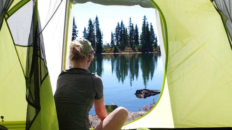 Experiential student enjoying the view from her tent