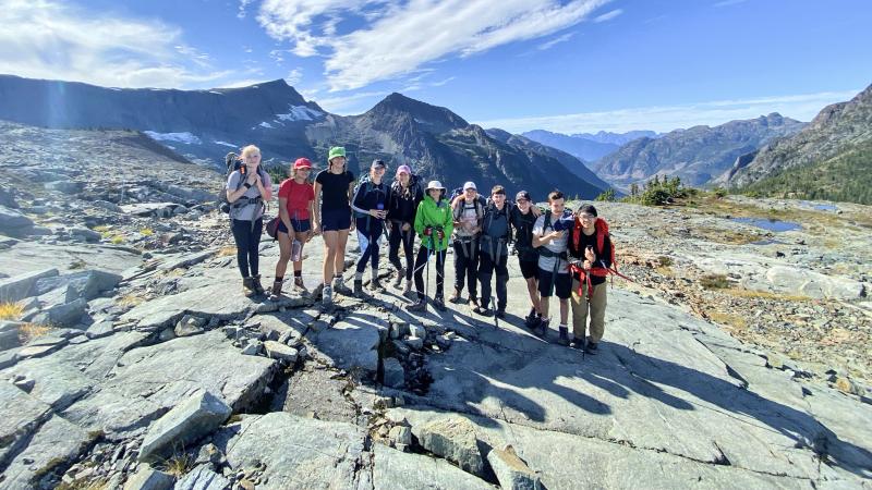 A group of students pose amid a beautiful natural backdrop during a hike in Strathcona Provincial Park