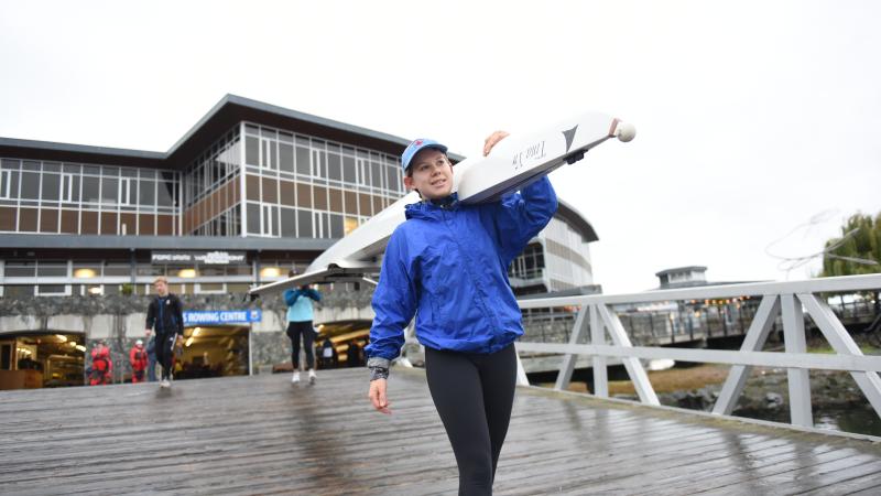 Senior School rowing athlete carrying a rowing shell