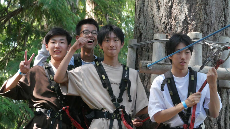 Students ziplining through the trees